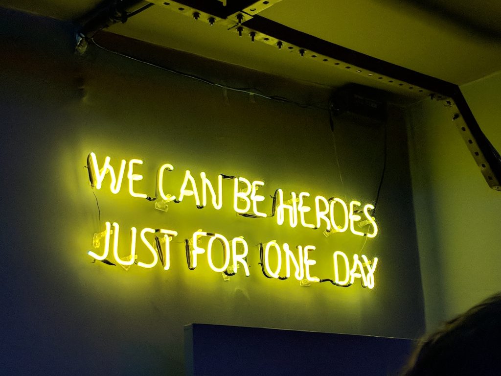 Ein gelbes Neon-Schild mit der Aufschrift: "We can be Heroes just for one day."