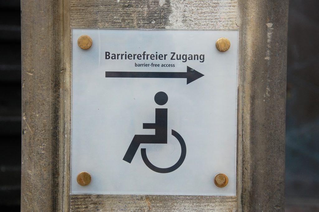 Schild auf dem ein Menschen mit Rollstuhl sowie der Text "Barrierefreier Zugang" zu sehen ist