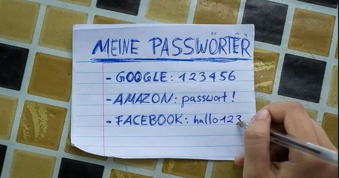 Ein Zettel liegt auf einem Tisch. Auf diesem steht "Meine Passwörter" gefolgt von einer unsicheren Passwort-Auflistung von Passwortauflistung von Google, Amazon und Facebook.