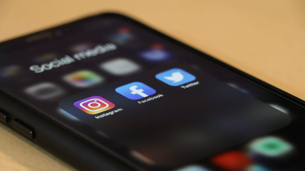 Smartphone mit Social Media Icons liegt auf einem Tich