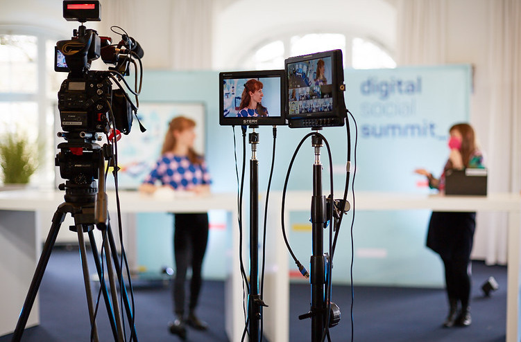 Verschwommen sieht man das Studio des Digital Social Summit 2021 durch zwei Kameras