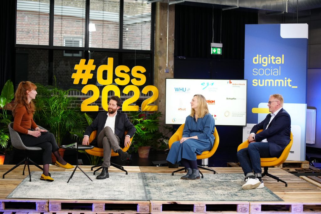 Bühnen-Foto von 4 Personen in Sesseln auf der Bühne des Digital Social Summit 2022.